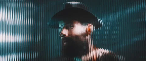 Man wearing hat viewed behind a clear line shaped panel using vintage camera Stock Footage 203570519