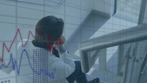Man wearing lab coat propping chin and causing animated clinical charts mapping 動画素材 312361023