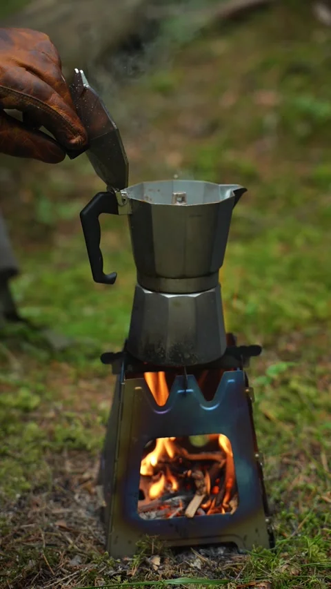 Man wearing leather glove opens the lid of a moka pot placed on a portable wood Video stock 312804053