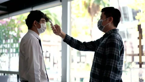 Man wearing mask checking temperature with infrared thermometer Stock Footage 156046364