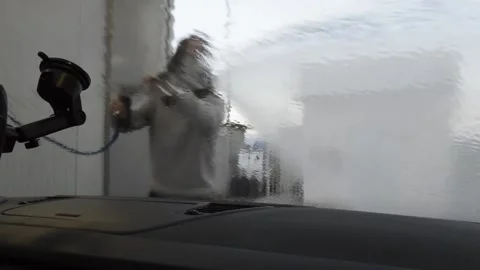 Man wearing a mask using a water pump at a car wash station 스톡 동영상 141582566