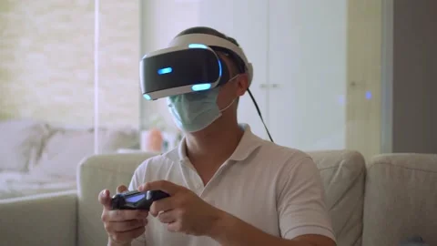 A man wearing mask while enjoying virtual reality game in his room Stock Footage 147176947