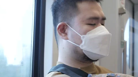 A man wearing mask while ridding subway public transportation in Bangkok look Stock Footage 184518953