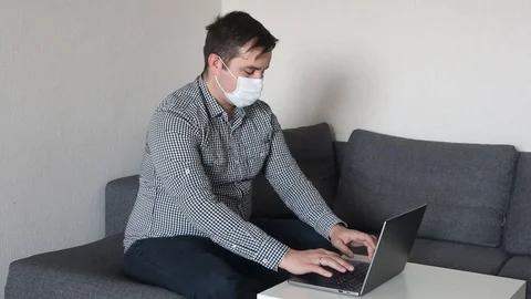 Man wearing mask working with computer from home office Stock Footage 126648277