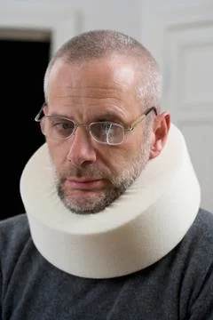 A man wearing a neck brace and cracked glasses Stock Photos