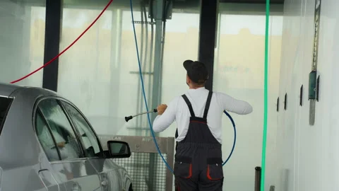 Man wearing overalls see use high-pressure water sprayer to clean shiny sil.. Stock Footage 320890802