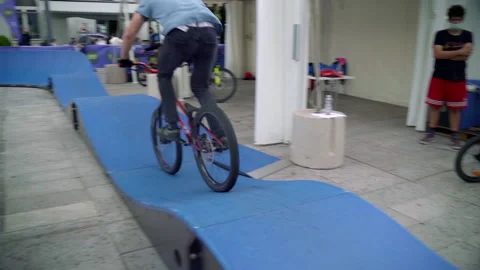 Man wearing pig mask doing stunts on bicycle 스톡 동영상 233670422