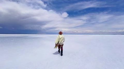 Man Wearing Poncho and Hat Walking in Salar de Uyuni Salt Flat, Bolivia Video stock 337476116