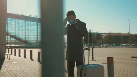 Man wearing Protective Face Mask sneeze coughs hold suitcase COVID-19 Stock Footage 126580386