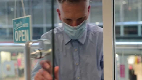 Man wearing protective face mask leaving shop uk Stock Footage 141464755