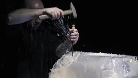 Man wearing protective goggles using chisel and hammer, ice sculpture artist, 4k Stock Footage 153587096