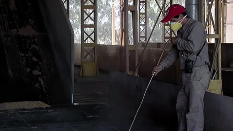 Man Wearing Protective Mask Cleaning Grain Unloading Area, Rosario - 4K Stock Footage 320852150