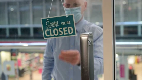 Man wearing protective mask closing shop uk Stock Footage 141464584