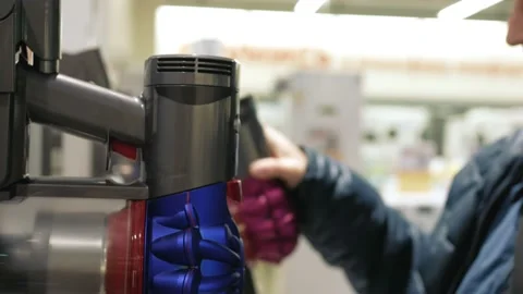 A man wearing a protective mask during a pandemic looks at vacuum cleaners in Stock-Footage 149900975