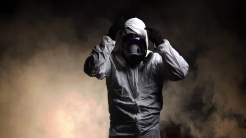 Man wearing protective suit and gas mask standing in fog 動画素材 221083122