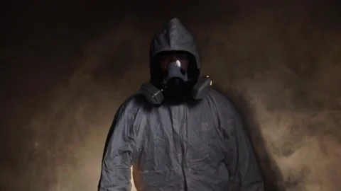 Man wearing protective suit and gas mask standing in fog Stock-Footage 221083185