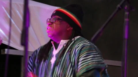 Man wearing rasta hat beating drums with his hands Stock Footage 45566212