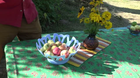 Man wearing red shirt placing ripe fresh apples in plastic bowl , 4K Stock Footage 59081434