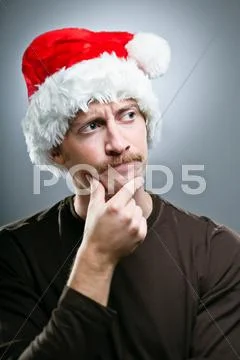 Man wearing santa hat thinking of what gifts to give Stock Photos