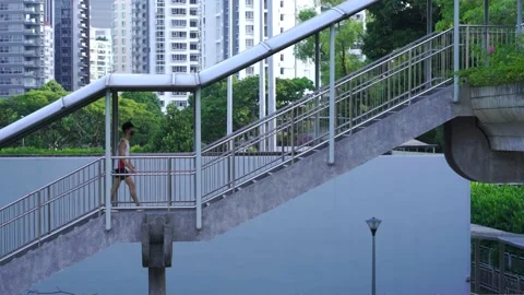 Man wearing singlet walking up covered staircase, overhead pedestrian Video stock 162468514