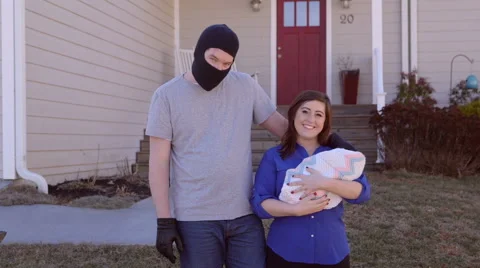 A man wearing a ski mask has his arm around a woman with a baby Stock Footage 63928064