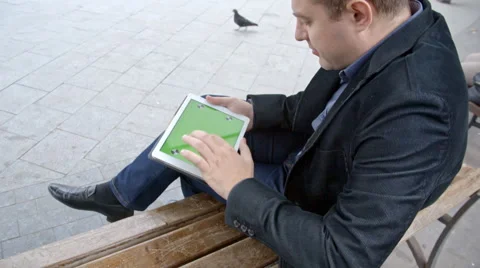Man Wearing Suit Working With Tablet On A Bench, Greenscreen Stock Footage 69069509