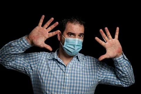 Man wearing surgical mask to protect himself from coronavirus posing with ope Stock Photos