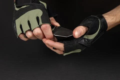 The man wearing tactical gloves using folding knife 스톡 사진