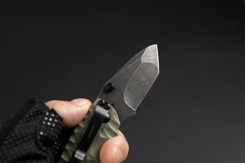 The man wearing tactical gloves using folding knife 스톡 사진