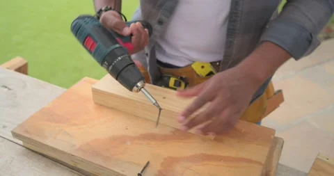 Man wearing tool belt using drill, driving screw, joining wood, inspecting parts Vídeo Stock 342721563