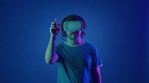 A man wearing virtual glasses scrolls an invisible screen with his finger and Stock Footage 252015786