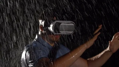 Man wearing virtual reality glasses in the rain. Slow motion. VR technolohy. Stock Footage 80307606