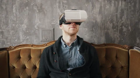 Man wearing virtual reality goggles. Studio shot, gray backgroun Stock Footage 62023717