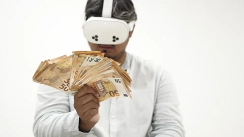 Man wearing virtual reality headset counting euro banknotes 스톡 동영상 309772692