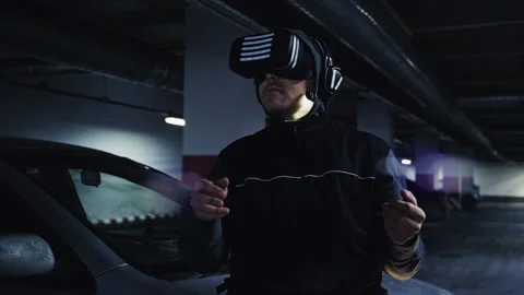 Man wearing virtual reality headset interacting in an underground parking lot 库存影片 332539052