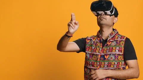 Man wearing virtual reality headset, doing swiping gestures, studio background Foto stock