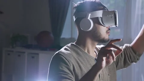 Man wearing VR goggles while playing video games with hands reaching out Stock Footage 167941100
