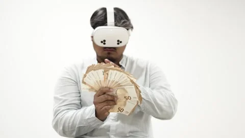 Man wearing VR headset counting Euro banknotes on white background 스톡 동영상 309772771