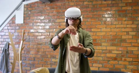 Man wearing VR headset following headset prompts, reaching, manipulating virtual Stock Footage 341952999