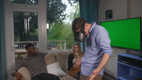 Man wearing VR headset with friends at home Stock Footage 89921171