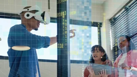 Man wearing VR headset gesturing at glass in office, activating binary grid for Stock Footage 332405506