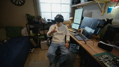Man Wearing Vr Headset Gesturing in Front of Computer Monitors Stock Footage 338425157
