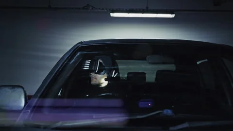 Man wearing vr headset parking car in garage Video stock 332539647