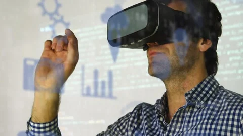 Man wearing VR headset raising right hand, selecting bar charts and code while Stock Footage 326974931