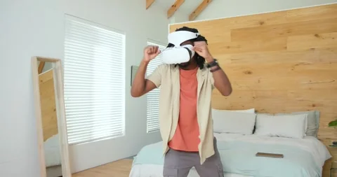 Man wearing white VR headset throwing punches, stepping and adjusting it in Stock Footage 340882345
