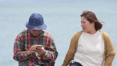 Man wears blue hat and plaid shirt, uses phone Видео 339975208
