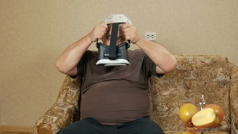 The man wears glasses at the age of virtual reality at home on the couch. He Stock Footage 71246167