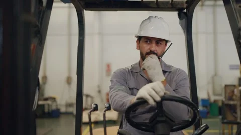 Man wears hard hat, grips forklift controls Stock Footage 340271130