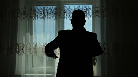 Man wears a jacket in front of a window contrast Stock Footage 96985676