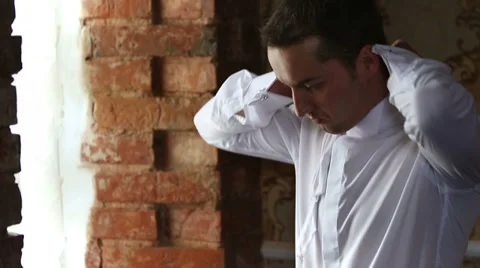 Man wears a tie at the window in the castle Stock Footage 39504658
